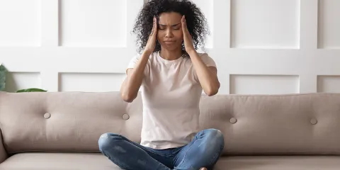 Pessoa com expressão de ansiedade ou ataque de pânico, com as mãos na cabeça, simbolizando sensação de perda de controlo