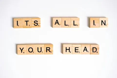Peças do jogo scrable formando a frase "It's all in your head"